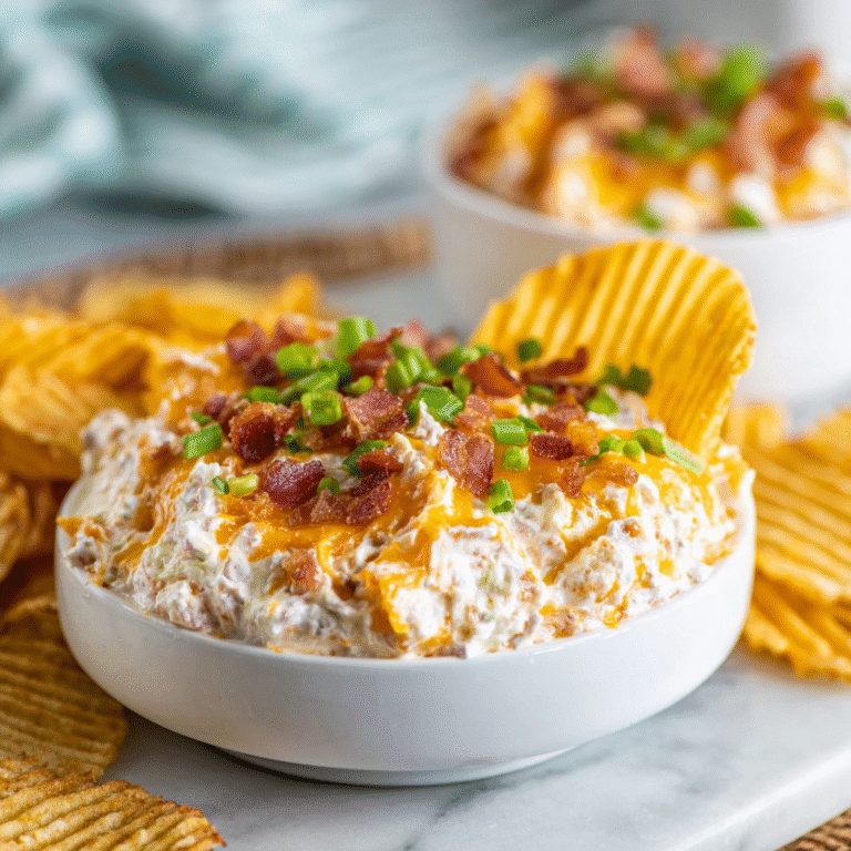 Loaded Baked Potato Chip Dip: The "Deconstructed Spud" Emulsion The Science of "Viscosity Balancing" Most potato chip dips suffer from being either too thin (runny) or too thick (breaking the chips). In 2026, we utilize Fat-Solid Stratification to create the perfect dip: The Base Emulsion: We combine Sour Cream (acidic/bright) with Cream Cheese (structural/fatty). The lactic acid in the sour cream thins the dense proteins of the cream cheese, creating a medium that is soft enough to scoop but strong enough to hold heavy toppings like bacon and potatoes. The "Starch-on-Starch" Effect: By folding in a small amount of finely mashed potato or instant potato flakes, we create a flavor bridge between the dip and the chip, while also stabilizing the moisture from the sour cream. Ingredients List The Creamy Matrix: Sour Cream (16 oz): Full fat provides the best mouthfeel. Cream Cheese (4 oz): Softened for smooth mixing. The "Loaded" Inclusions: Crispy Bacon (6 strips): Finely crumbled. Sharp Cheddar Cheese (1 cup): Shredded from a block (pre-shredded is too waxy). Green Onions (4): Thinly sliced (whites for the mix, greens for garnish). Mashed Potato (1/4 cup): Or 2 tbsp instant flakes (the "secret" body-builder). The Seasoning "Punch": Garlic Powder & Onion Powder (1 tsp each). Smoked Paprika (1/2 tsp): For that "baked over a fire" essence. Black Pepper (to taste). Timing: The "Flavor-Meld" Window Prep: 15 minutes. Chilling (Essential): 1 hour. The "Warm-Up": 10 minutes before serving. Step-by-Step Instructions Step 1: The "Soft-Base" Blend In a large bowl, whip the softened cream cheese until smooth. Gradually fold in the sour cream until no lumps remain. Actionable Advice: Use a hand mixer for 60 seconds. This aerates the fats, making the dip feel lighter on the palate even though it’s rich. Step 2: The Starch Integration Stir in the mashed potato or flakes and the dry seasonings. The 2026 Pro-Tip: The potato solids act as an "anchor," absorbing the liquid that usually separates from sour cream (syneresis), keeping your dip fresh for days. Step 3: The Loading Fold in 75% of your bacon, cheddar, and onion whites. Save the remaining 25% for the "visual reveal" on top. Step 4: The Cold Cure Cover and refrigerate for at least one hour. The Science: Cold temperatures allow the onion and garlic powders to hydrate, deepening the flavor profile from "salty" to "savory." Step 5: The Final Garnish Top with the reserved bacon, cheese, and green onion tops. Serve with kettle-cooked chips (the only chips strong enough to handle this density). Common Mistakes to Avoid Using Warm Bacon: If the bacon is still hot when you fold it in, it will melt the fat in the cheese and turn the dip greasy. Let it cool to room temperature first. Over-mixing the Toppings: If you stir the bacon and onions too vigorously, the dip will turn a murky grey-brown color. Gently "fold" them in. Skipping the Salt Check: Chips are salty. Taste the dip without extra salt first; usually, the bacon and cheese provide all the sodium you need. 3 Modern Pairings for 2026 Dipping Vessel Why it Works Kettle Salt & Pepper Chips The extra pepper adds a sharp bite to the creamy base. Waffle Fries Turns the dip into a "deconstructed" appetizer meal. Chilled Celery Sticks Provides a watery, crisp crunch for a lighter alternative. Would you like me to show you how to turn this into a "Warm Loaded Dip" using a skillet and a layer of melted mozzarella?
